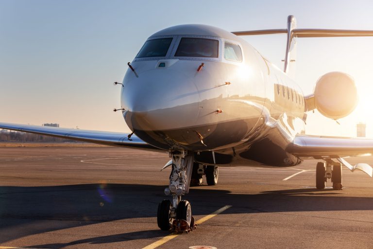 Scenic front view of a private jet plane parked on the airport taxiway.