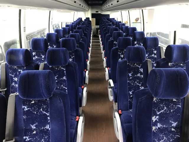 Interior of a full-size charter bus with reclining seats
