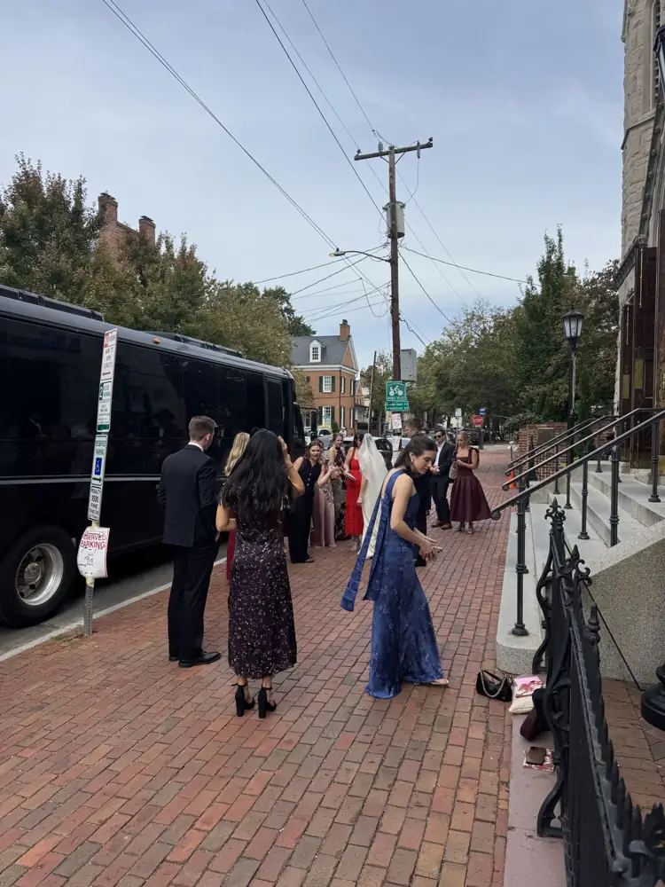 Bride and bridal party walking to an RDV Limousine party bus after the ceremony in Old Town Alexandria