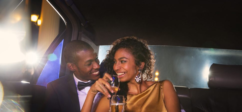 young couple having champagne in a limo